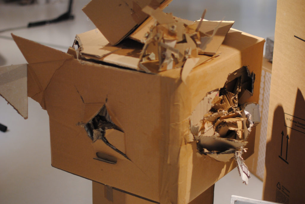 Carton explosé, dont sortent d'autres cartons déchiquetés